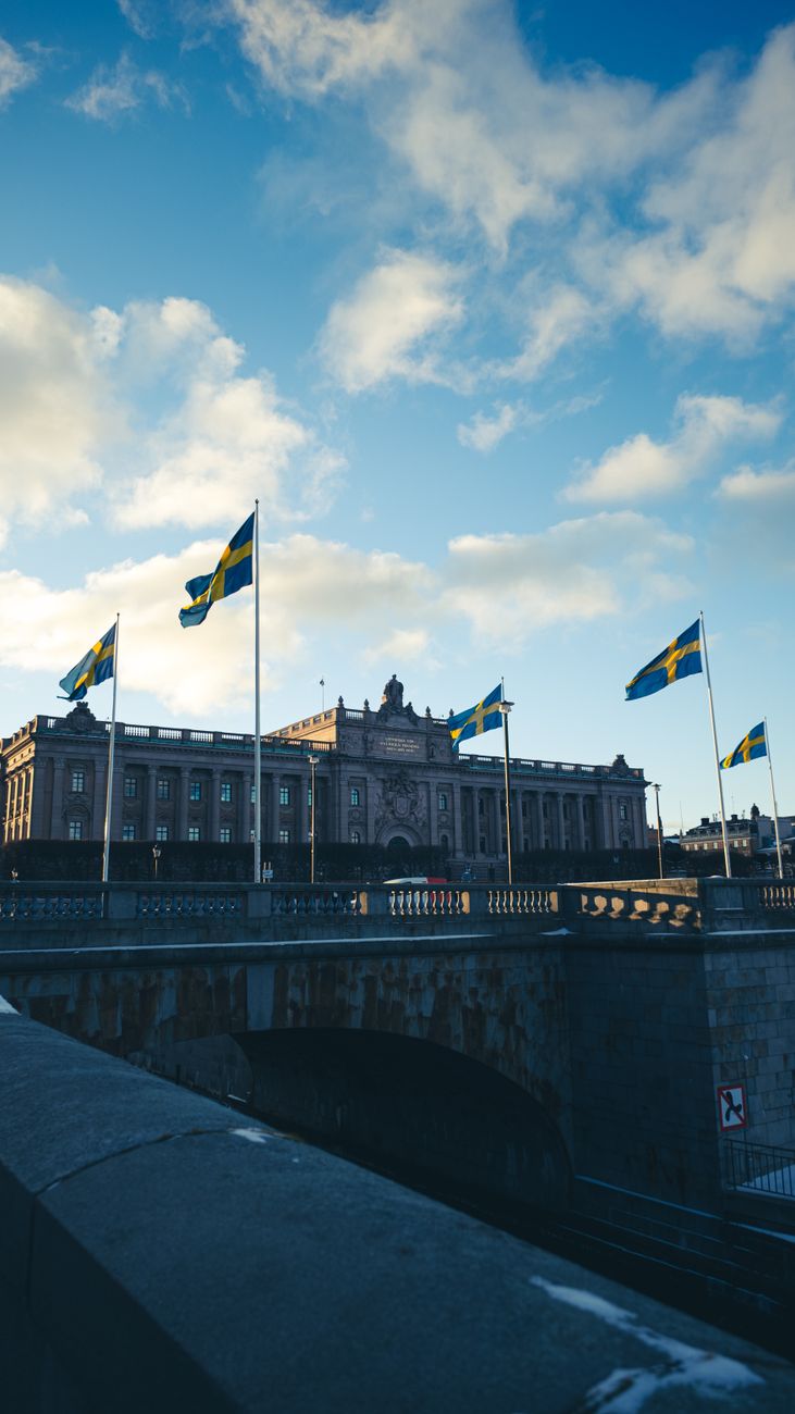 swedish parliament building with flags in stockholm